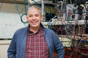 Mark Saffman poses in front of equipment in his lab