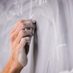a hand writing on a chalkboard