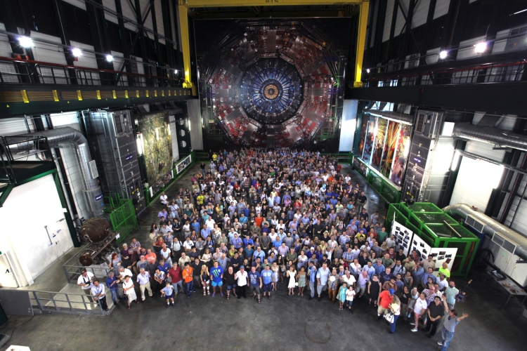 hundreds if not thousands of people stand in front of the CMS detector