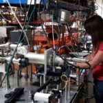 a teacher works with equipment in a quantum science lab